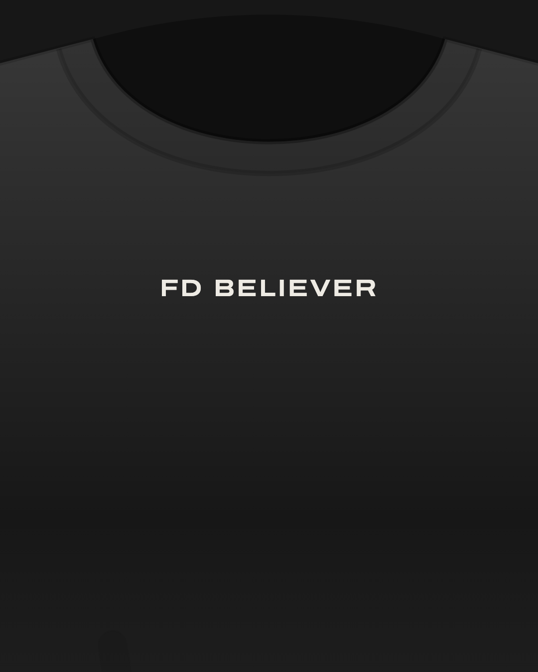 Close-up of a black tee with “FD believer” printed small in off-white on the chest