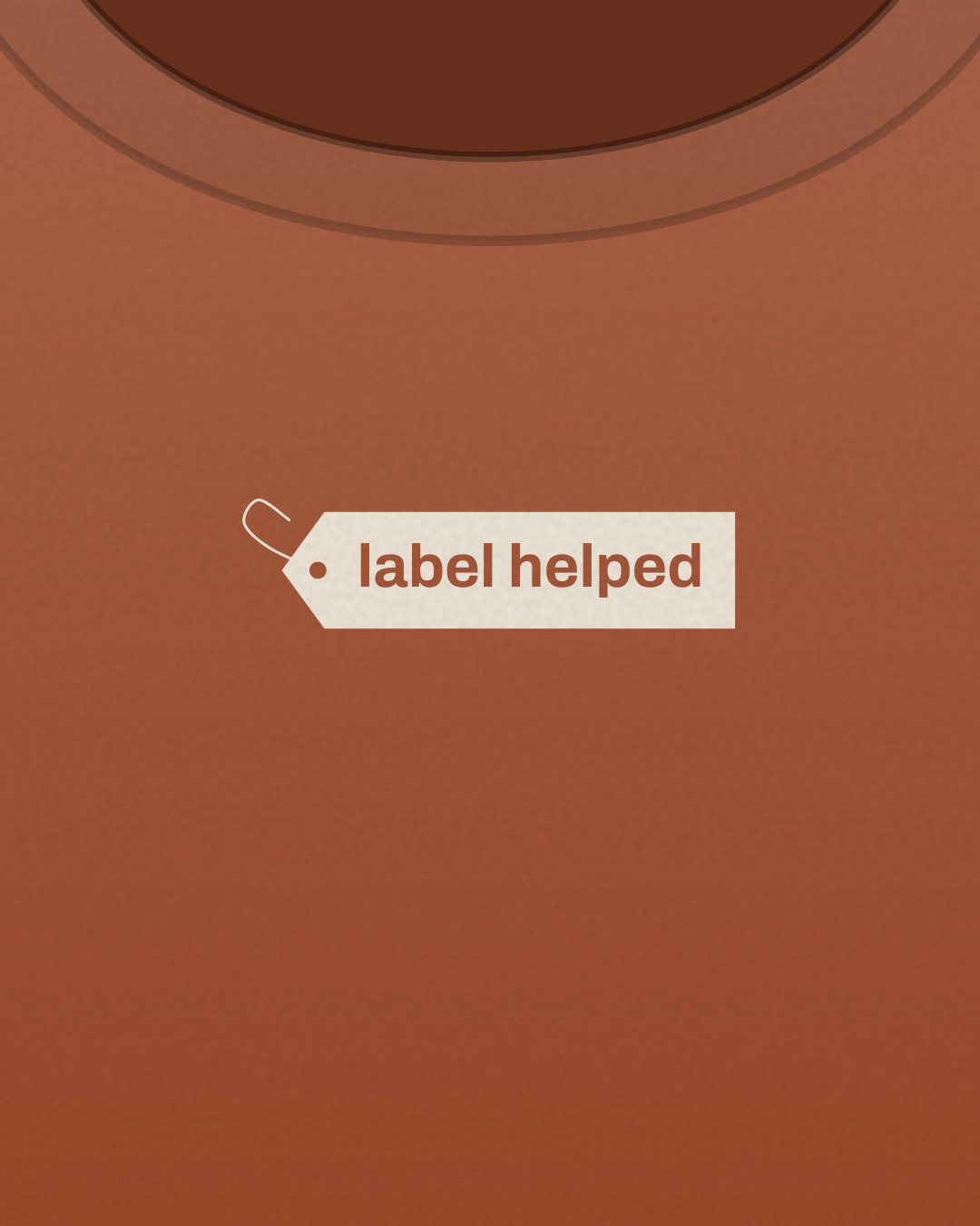 Close-up of the “label helped” print in cream on a rust tee