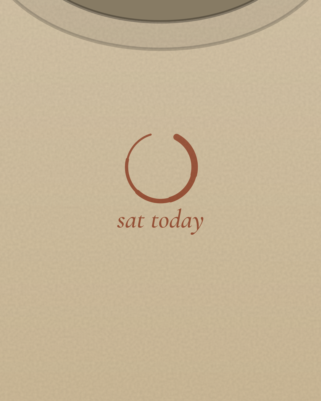 Close-up of the “sat today” print in rust on a sand tee