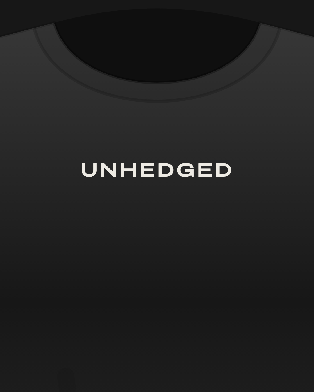Close-up of a black tee with “Unhedged” printed small in off-white on the chest