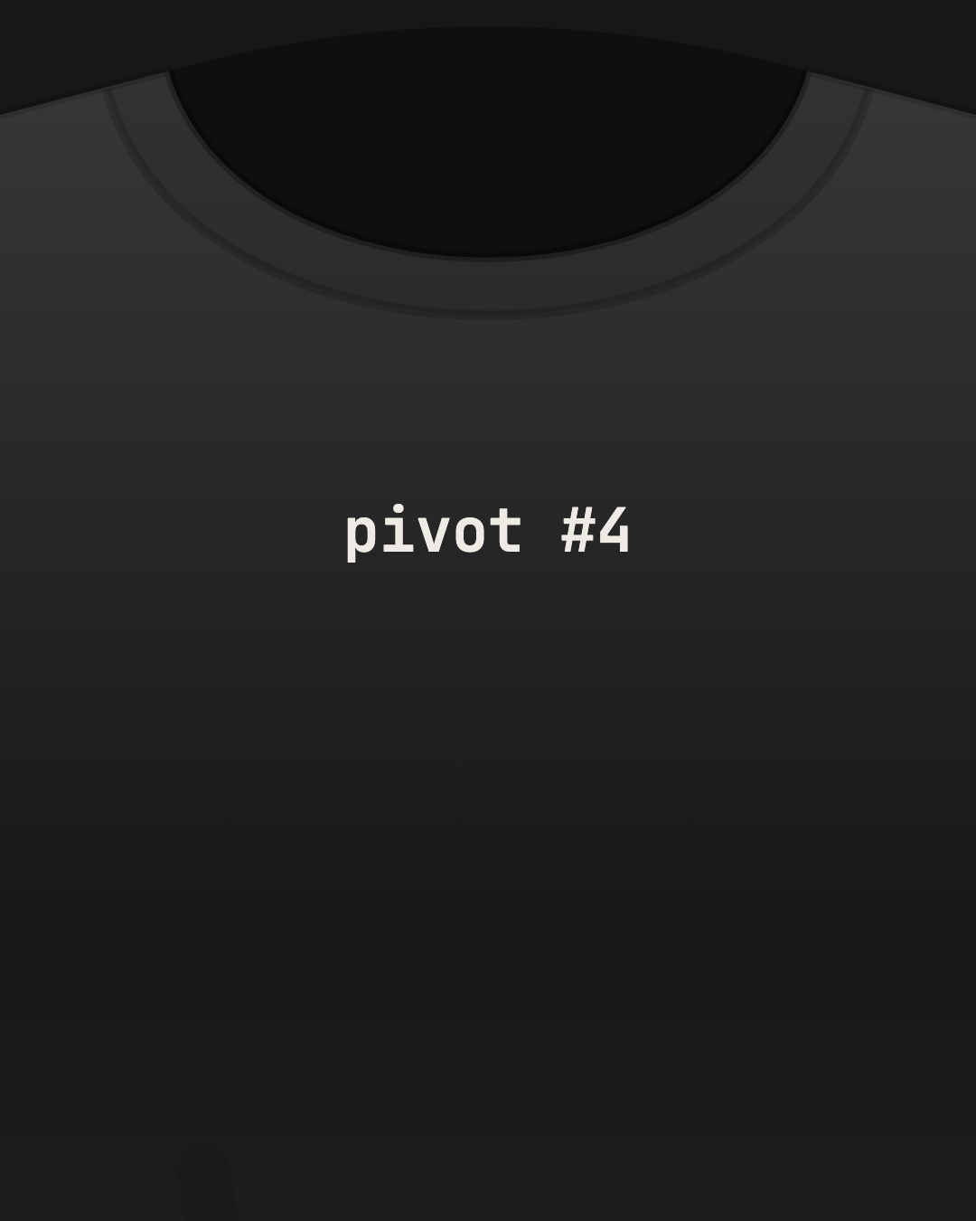 Close-up of a black tee with “pivot #4” printed small in off-white on the chest