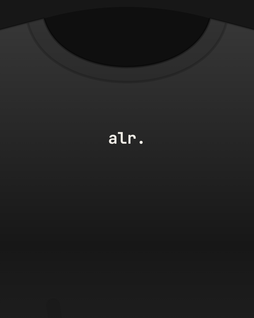 Close-up of a black tee with “alr.” printed small in off-white on the chest