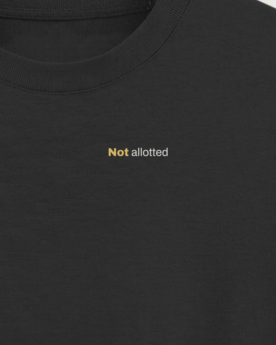 Mockup: close-up of “Not allotted” printed on a jet black oversized tee